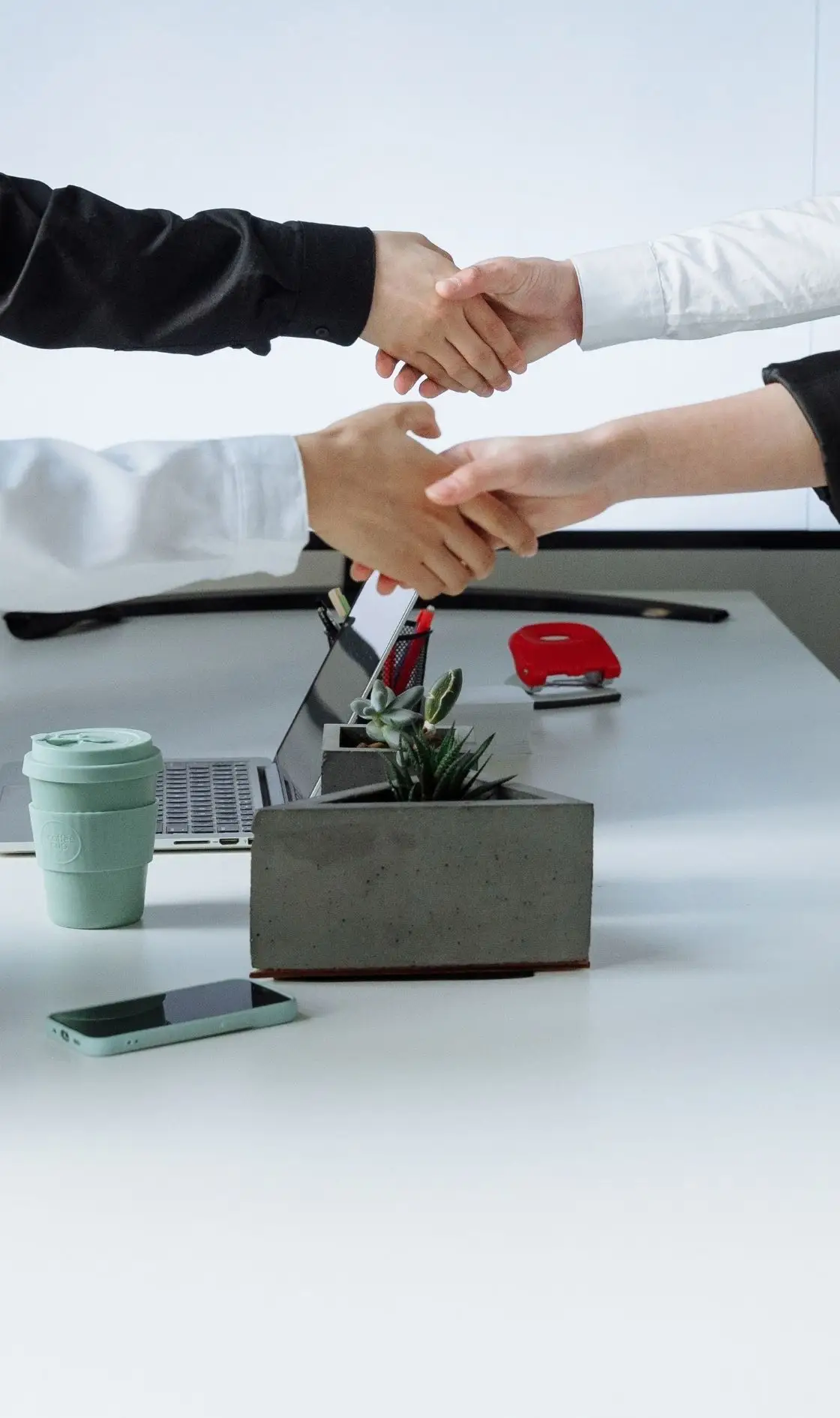 Handshake over a desk sealing a hiring agreement