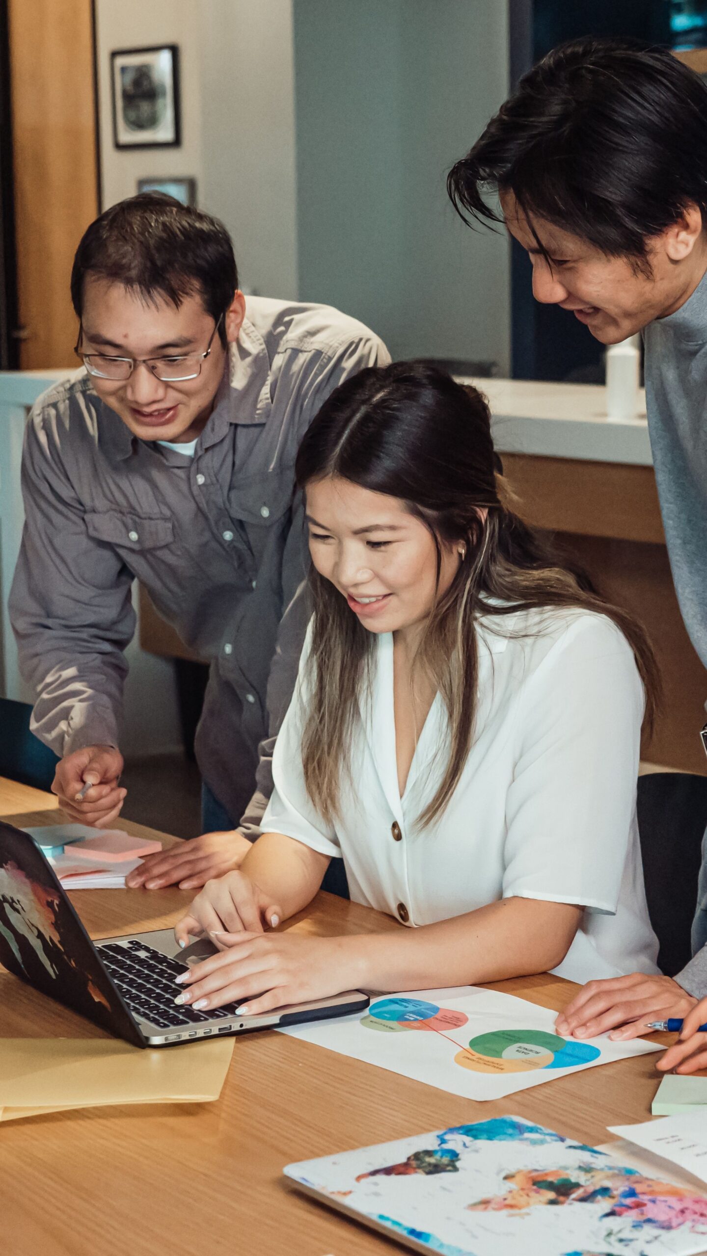 Colleagues reviewing work together on a laptop