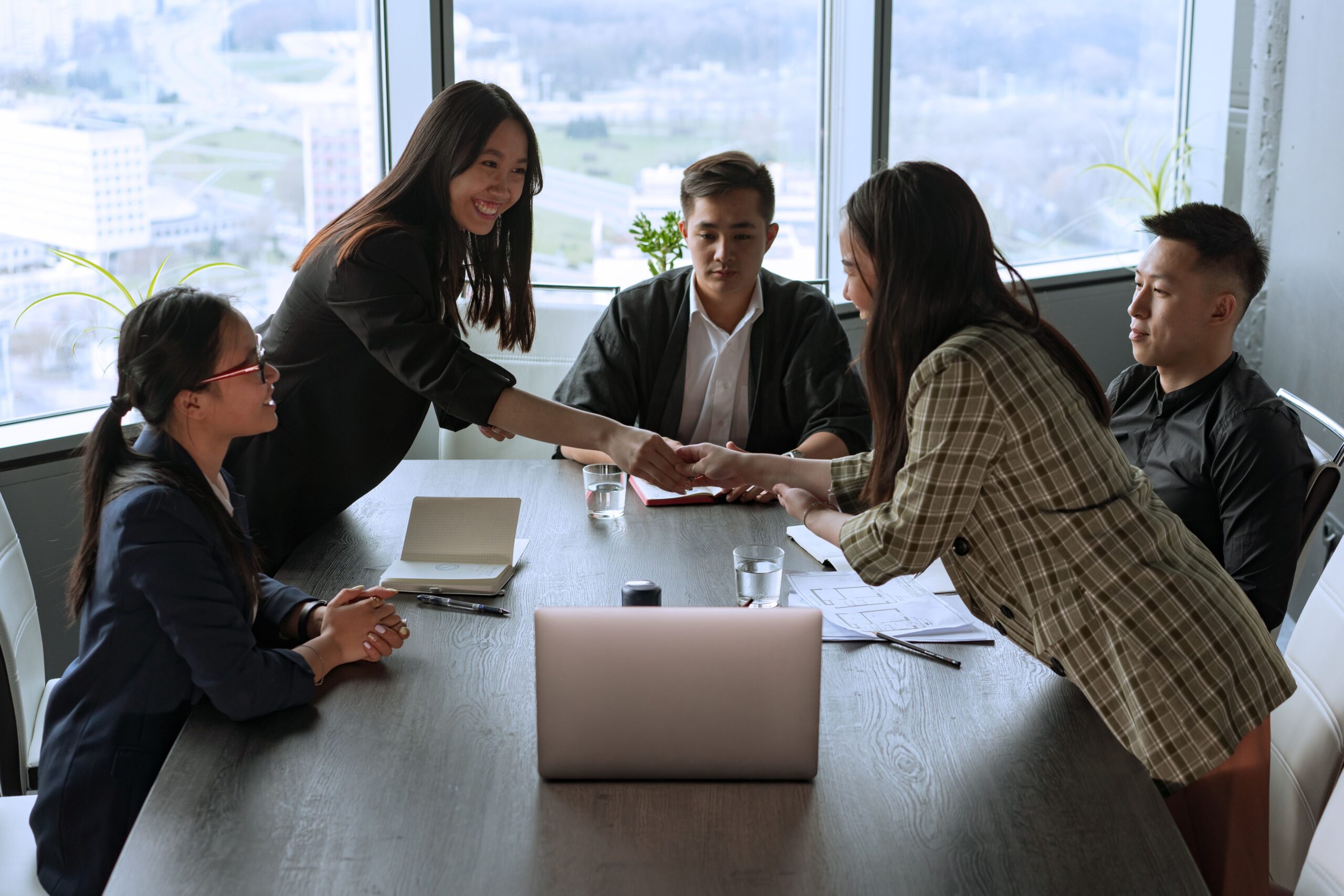 Recruiter shaking hands with a candidate across a meeting table