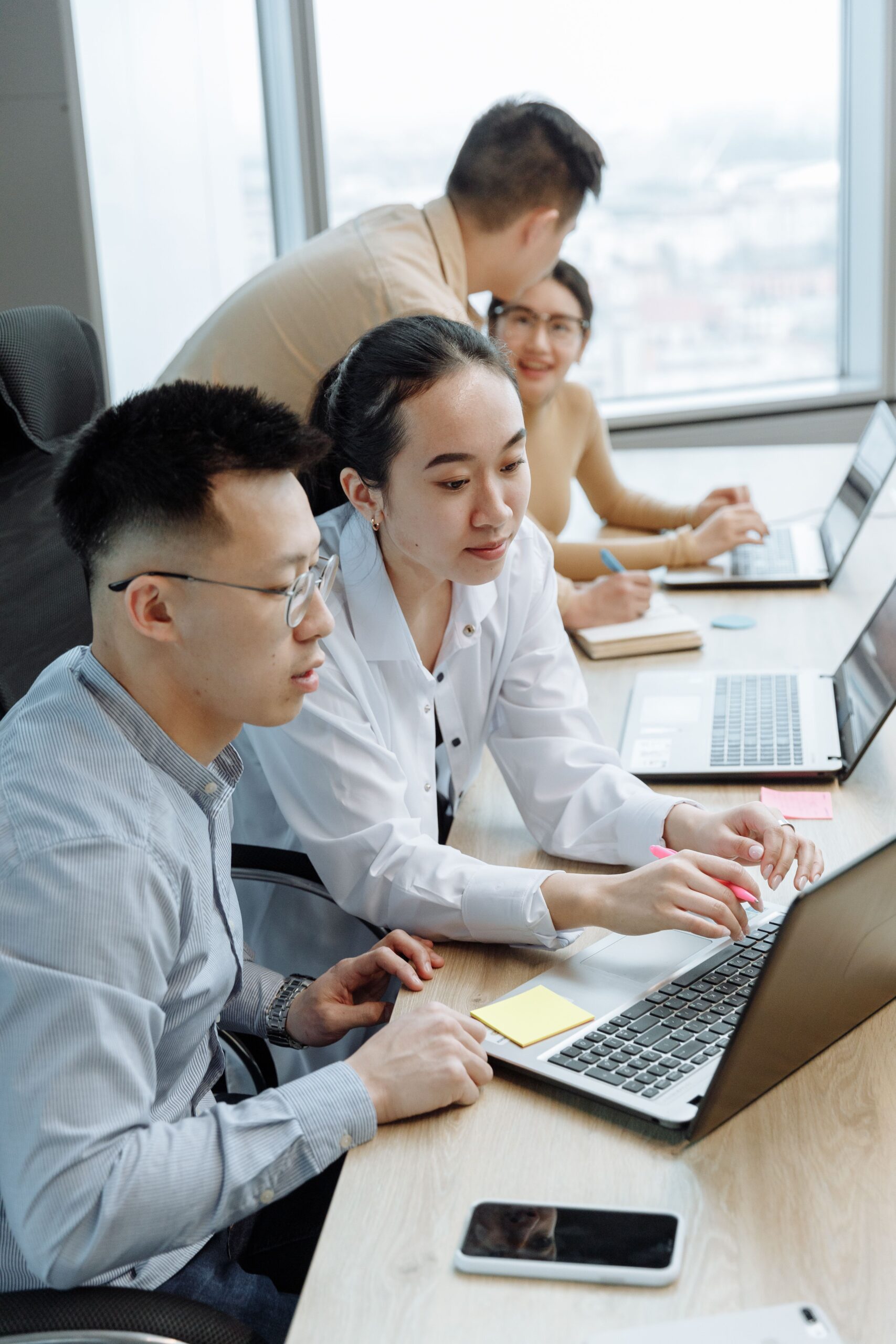 Team working on laptops around an office desk